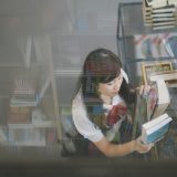 读者头像占位图，一位正在对照两份材料做标记的读者侧影
